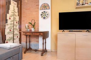 uma sala de estar com uma televisão e uma mesa de madeira em A due passi dal lago em Laveno-Mombello