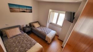 een kleine slaapkamer met een bed en een raam bij Casa Barca Velha in Ponte da Barca