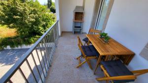 a porch with a wooden table and chairs on a balcony at Casa Barca Velha in Ponte da Barca