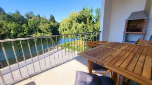 a balcony with a wooden table and a view of the water at Casa Barca Velha in Ponte da Barca