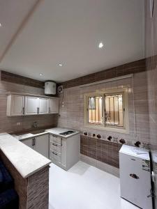 uma cozinha com armários brancos e uma janela em سجى للوحدات السكنية em Abha