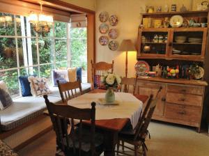 comedor con mesa, sillas y ventana en Southdown Cottage, en Bowral