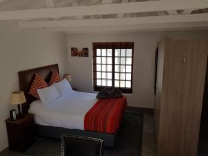 a bedroom with a large bed and a window at Karibu Self-catering Accommodation in Hermanus