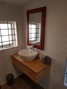 y baño con lavabo blanco y espejo. en Karibu Self-catering Accommodation, en Hermanus