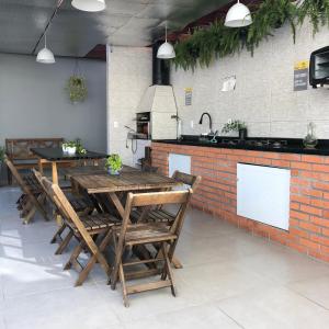 a restaurant with wooden tables and chairs and a kitchen at Pousada Crisana in Florianópolis