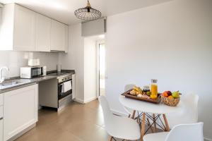 a kitchen with a table with a bowl of fruit on it at Casa das Rosas - Roses House in Miranda do Corvo