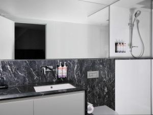 a white kitchen with a sink and a shower at Movenpick Hotel Melbourne On Spencer in Melbourne