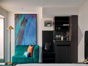 uma sala de estar com uma cadeira verde e uma mesa em Movenpick Hotel Melbourne On Spencer em Melbourne