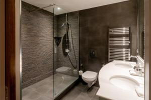 a bathroom with a shower and a toilet and a sink at The Petersham in Richmond upon Thames