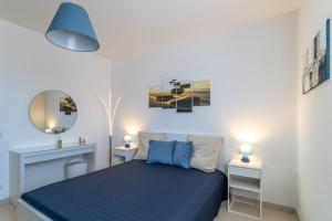1 dormitorio con 1 cama azul y 2 mesitas de noche en Brezzadisudest, en Marina di Ragusa