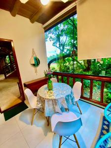 a dining room with a table and chairs and a large window at Housing 31 - Cond. Mata Azul - frente á entrada 18 in São Sebastião