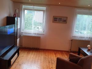 a living room with two windows and a wooden floor at Ferienwohnung BeLu in Velden am Wörthersee