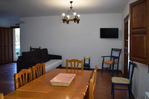 a dining room and living room with a table and chairs at Apartamentos Rurales la Taberna in Matienzo