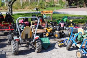 a bunch of childrens tractors andicycles parked in a lot at "Ferienhof Seelust" Ferienwohnung Lerche in Gammendorf