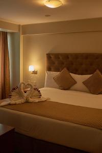 a bedroom with a large bed with a large headboard at Casona Plaza Hotel Arequipa in Arequipa