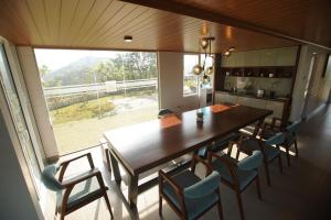 a kitchen with a table and chairs and a large window at Cinnamon Serenity Villa in Badulla