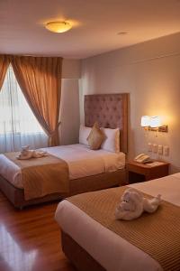 a hotel room with two beds and a window at Casona Plaza Hotel Arequipa in Arequipa