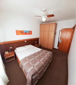 sypialnia z łóżkiem i drewnianą szafką w obiekcie Union Residence HEER w mieście Novo Hamburgo