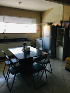 a kitchen with a table and chairs and a refrigerator at Apartamento para temporada perto do aeroporto de Brasilia in Brasilia