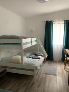 a bedroom with a bunk bed with a ladder at Arvisura Vendégházak family friendly transit apartments in Zsombó