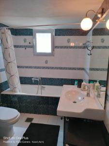 a bathroom with a sink and a tub and a toilet at Katakolo 180ο Sea View house near Ancient Olympia in Katakolon