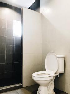 a bathroom with a toilet and a shower at โรงแรมบ้านเพิ่มสุข อิมแพ็ค เมืองทอง in Pak Kret