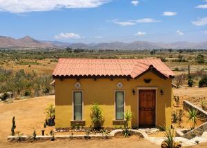 a small yellow house in the middle of a field at The Bungalow @Terra Monarca in El Porvenir