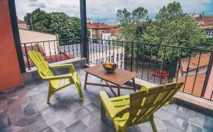 einen Balkon mit 2 Stühlen und einem Tisch auf dem Balkon in der Unterkunft ADEO HOTEL Sport & SPA in Ruse