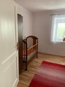 ein Babyzimmer mit einem Kinderbett und einem roten Teppich in der Unterkunft ZBYTINY in Zbytiny