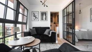 a living room with a couch and a table at Flatbook - City Center SPA Apartments Dwie Motlawy in Gdańsk