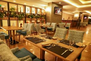 a dining room with tables and chairs in a restaurant at Sun Erbil in Erbil