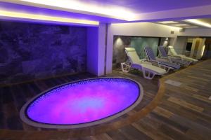 Sun Erbil في أربيل: غرفة سبا مع حمام سباحة أرجواني كبير