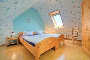 a bedroom with a wooden bed in a attic at "Ferienhof Seelust" Reihenhaus 8 in Gammendorf