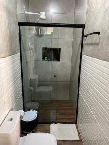 a bathroom with a toilet and a glass shower at Pousada Luar do Prata in Trindade