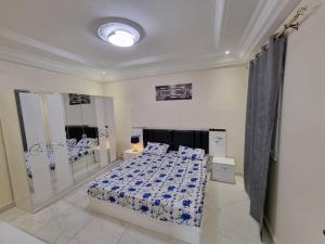 sypialnia z łóżkiem z niebieską i białą pościelą w obiekcie SUPERBE APPARTEMENT MEUBLÉ AU BORD DE LA PLAGE w mieście Mbaw