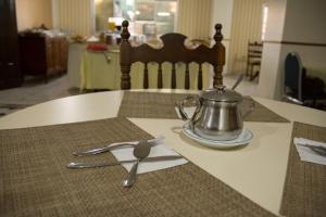a table with a tea kettle and utensils on it at Mariano Palace Hotel in Campinas
