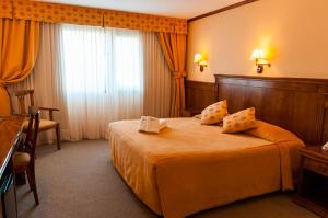 a hotel room with a bed and a window at Konke Calafate Hotel in El Calafate