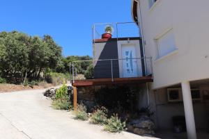 a house with a porch with a potted plant on it at Appartement 50 m2 avec parking gratuit sur place in Vailhauquès