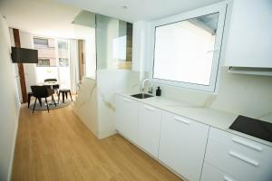 eine Küche mit weißen Schränken, einem Fenster und einem Tisch in der Unterkunft Total Valencia Torres de Quart in Valencia + 49 Fotos