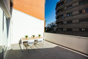 ein Balkon mit Tisch und Stühlen auf einem Gebäude in der Unterkunft Total Valencia Torres de Quart in Valencia