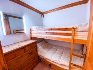 a bedroom with two bunk beds and a mirror at SkiMottaret in Méribel