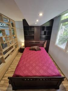 1 dormitorio con 1 cama grande de color rojo en una habitación en Бутиков Апартамент - Тракия, en Shumen