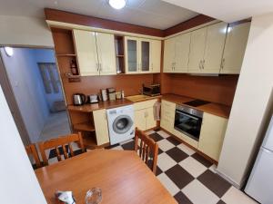 een kleine keuken met witte kasten en een tafel bij Бутиков Апартамент - Тракия in Shumen