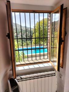 ventana con vistas a la piscina en Casa el Castano, en Martos