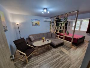 uma sala de estar com um sofá e uma mesa em Бутиков Апартамент - Тракия em Shumen