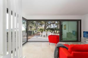 a living room with a red couch and a sliding glass door at 4 Bedroom Modern House, Llafranc, Costa Brava in Llafranc