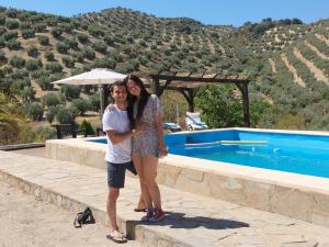 un hombre y una mujer parados junto a una piscina en Casa el Castano, en Martos