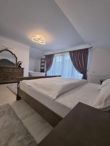 - une chambre avec un grand lit et une fenêtre dans l'établissement Căsuța dintre brazi, à Râșnov