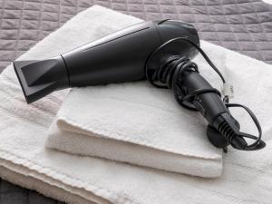 a black blow dryer sitting on a pile of towels at Pass the Keys Elegant stylish home in historic town centre sleeps 3 in Moreton in Marsh