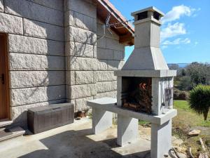 een stenen open haard buiten een huis bij Lobetios - Casa rural in Parada de Achas